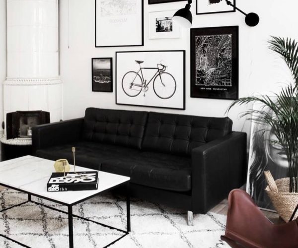 Black-tufted-sofa-in-modern-contemporary-living-room-with-white-marble-table-and-gallery-wall