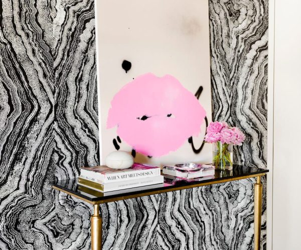 Entryway-with-black-and-white-wallpaper-and-bold-pink-artwork